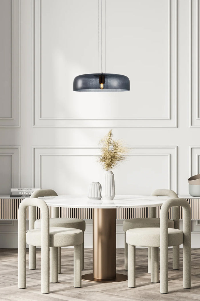 Single tiered smokey black glass pendant over a dining space.