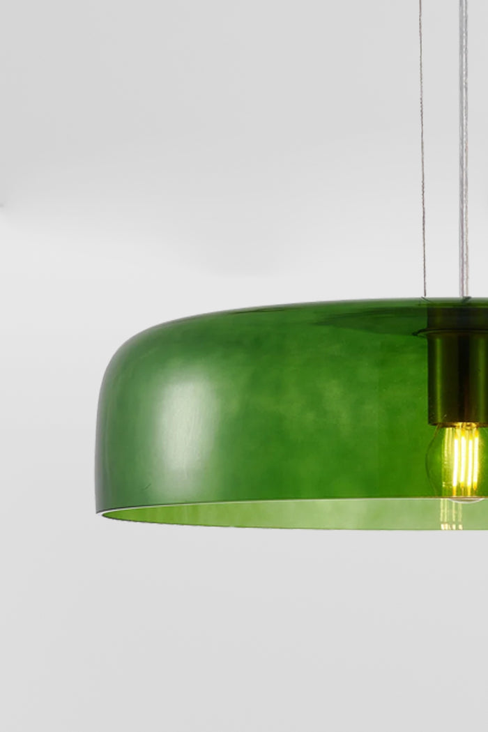Close up of the single tiered green glass pendant light with the light on.