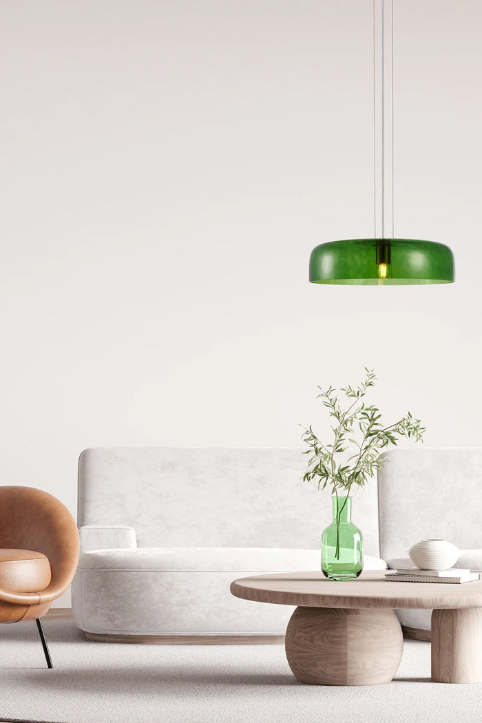 Single tiered green glass pendant light in a lounge area.