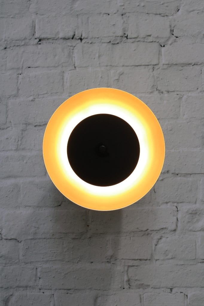 Dome wall light with gold/brass shade and black disc