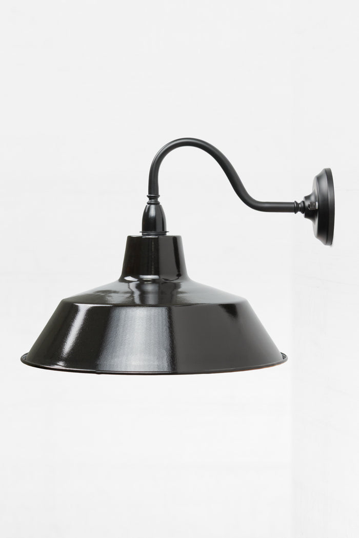 Side view of the exterior wall sconce with a black gooseneck arm and large shade.