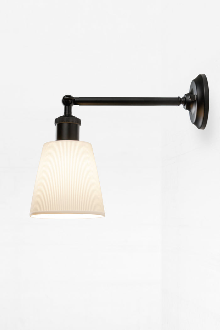 Large ceramic shade on a outdoor wall sconce in black with a swivel lampholder.