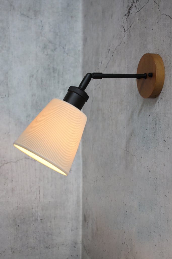 Side angle of a ceramic shade on a tiltable wall arm
