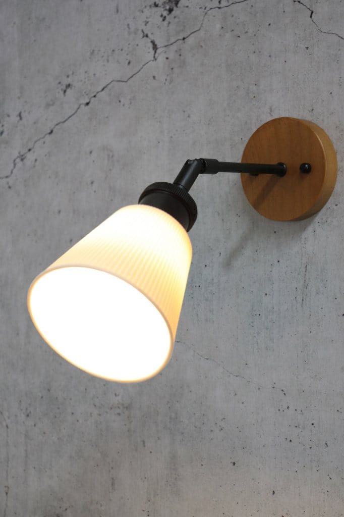 Small ceramic tiltable wall light with a wooden mounting block