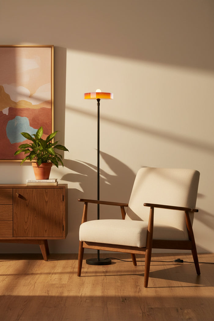 Amber omber glass shade paired with a black stemfloor lamp in a mid century modern inspired reading nook.