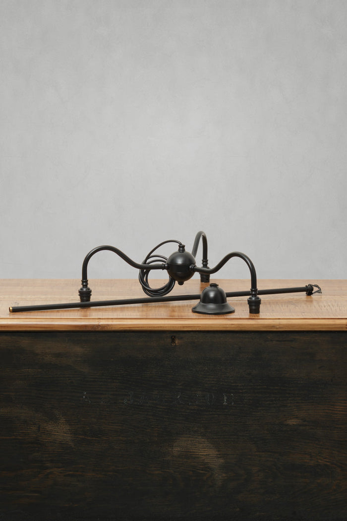 Matt black brass three arm gooseneck fixture.