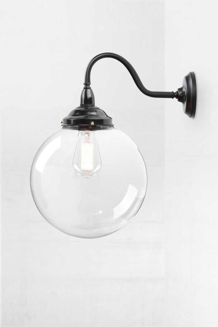 Black gooseneck outdoor wall light with a bakelite gallery and medium clear glass ball shade.