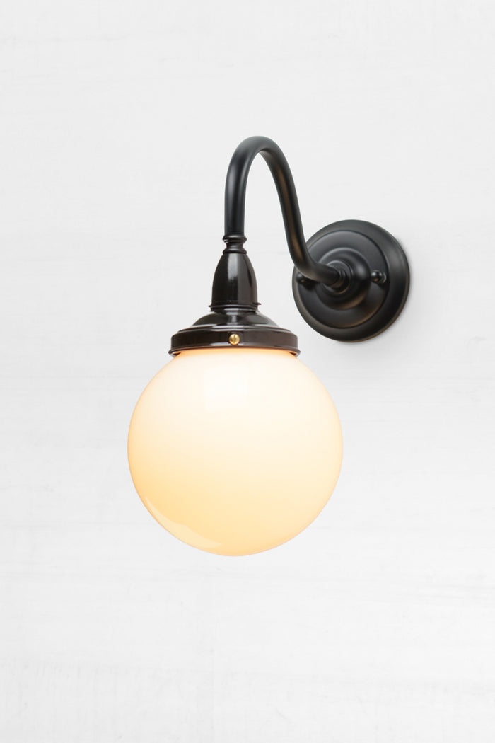 Small exterior gooseneck wall sconce with opal glass ball shade.
