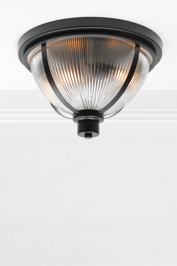 Ceiling light made up of a Reeded glass dome shade with black banded metal ware.