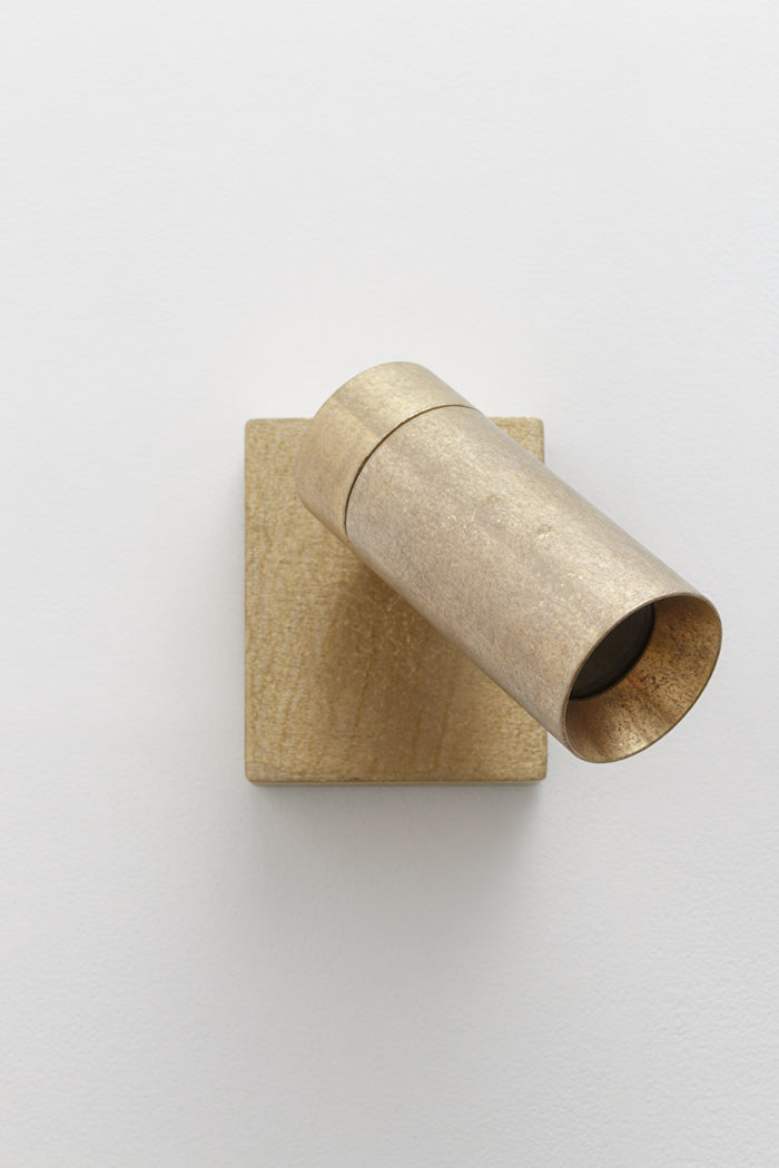 Antique brass adjustable wall spotlight with cylindrical shade and square wall mount on a white background.