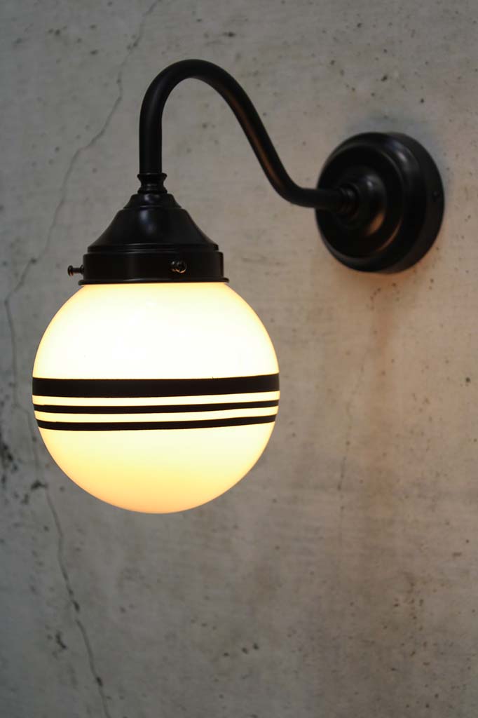 Hand painted opal glass ball pendant light with three stripes on black steel sconce.