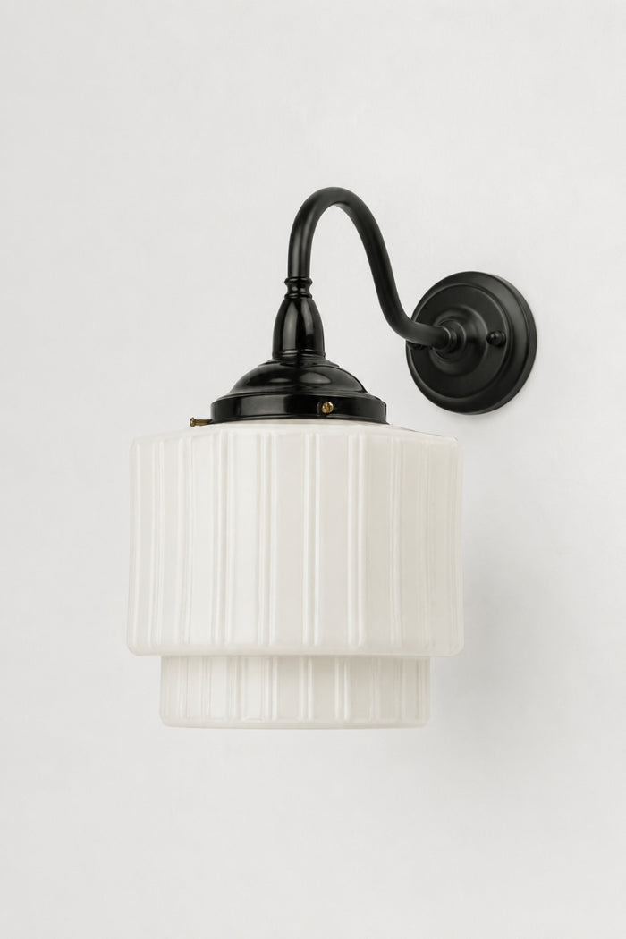 Opal glass shade with vertical detailing on a black gooseneck wall light.