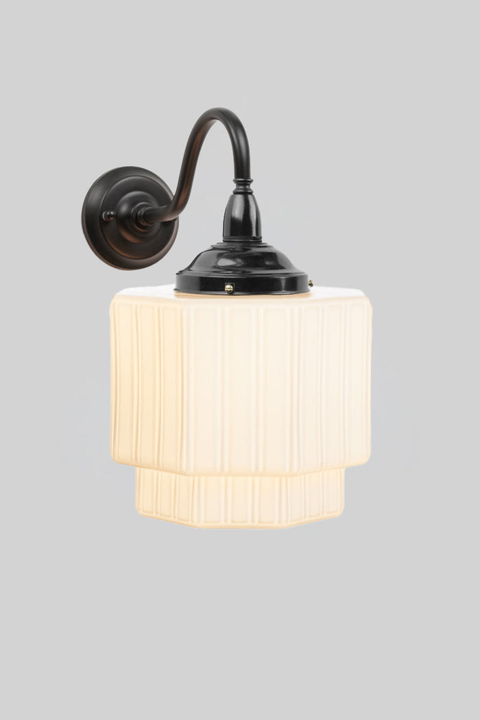 Outdoor wall light with art deco influence with an opal glass shade and black arm.