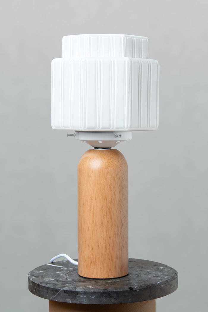 Harcourt Wood Table Lamp with stepped opal glass shade, natural wood base and black marble surface.