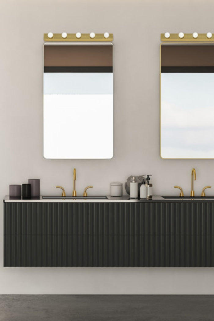 Two brass linear vanity LED lighs over mirrors
