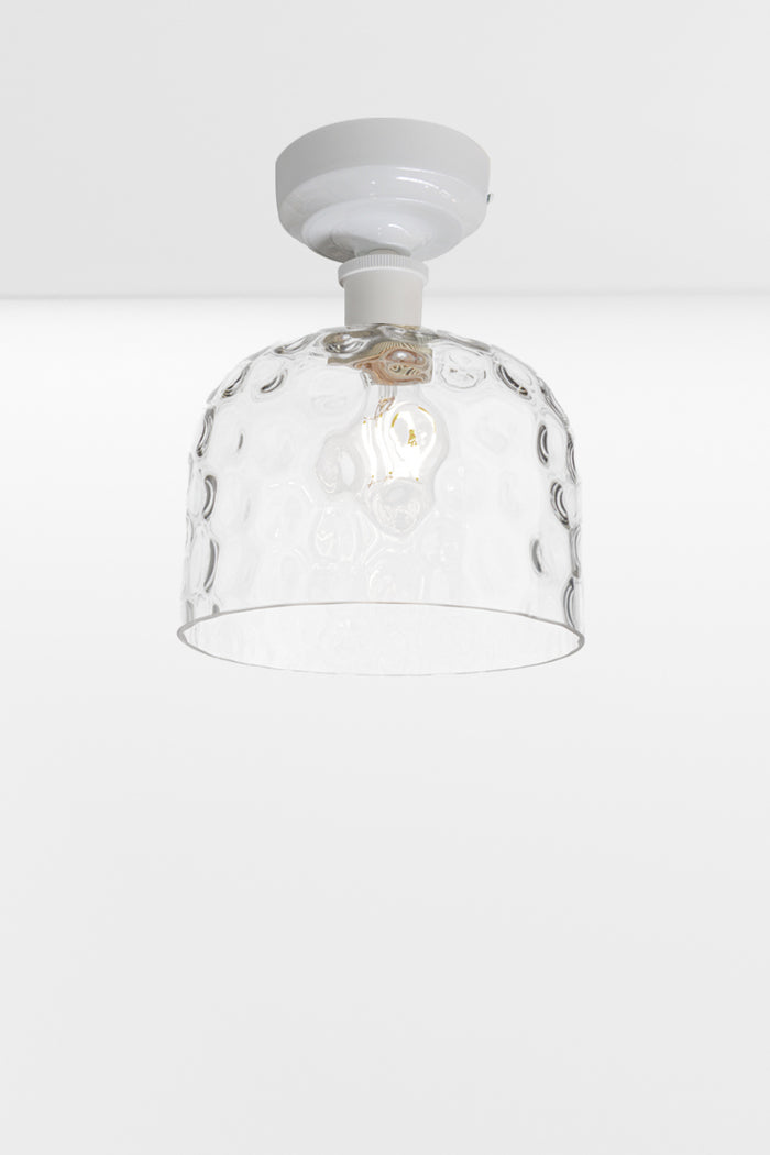 Clear glass shade with dimpled detailing paired with a white batten holder.