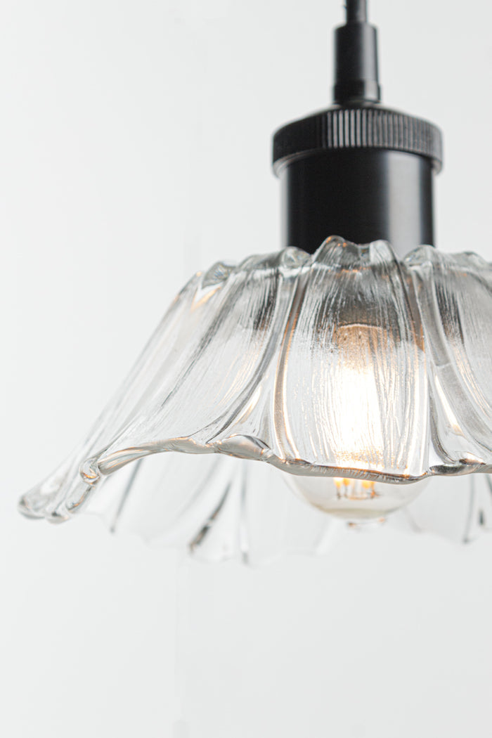 Honfleur clear fluted glass pendant light with black suspension cord and matching black metalware.