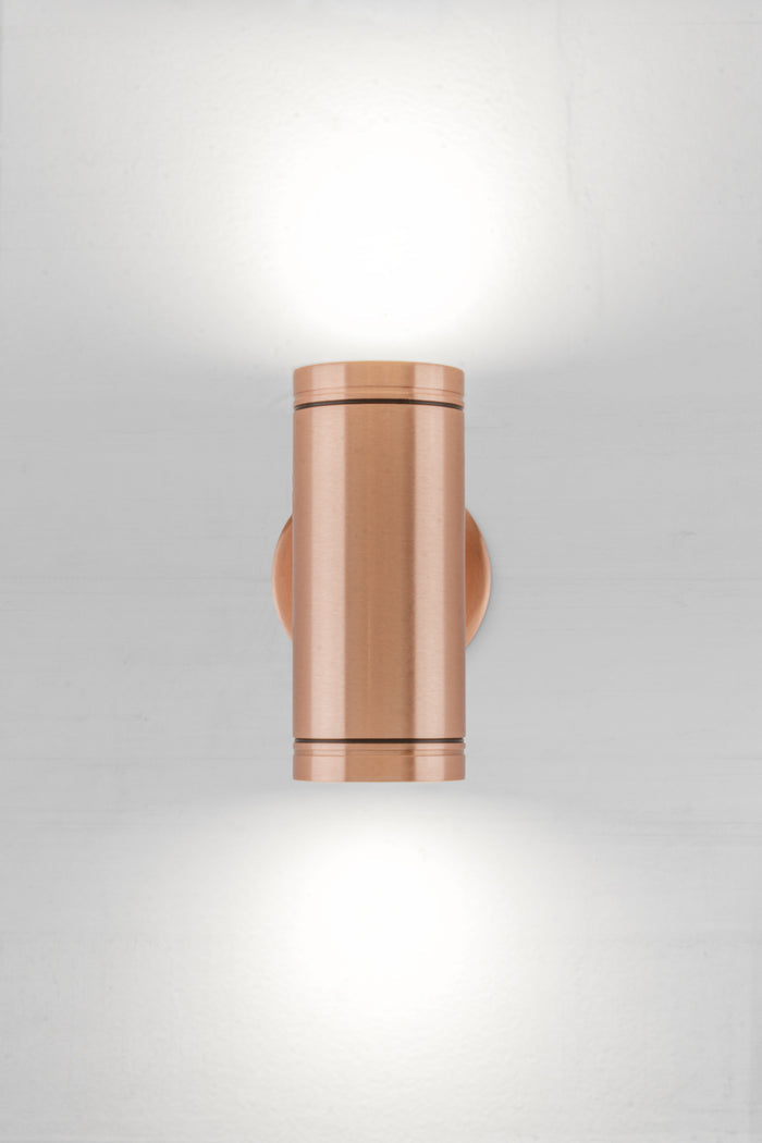 Solid copper up/down wall spot light with a polished finish.