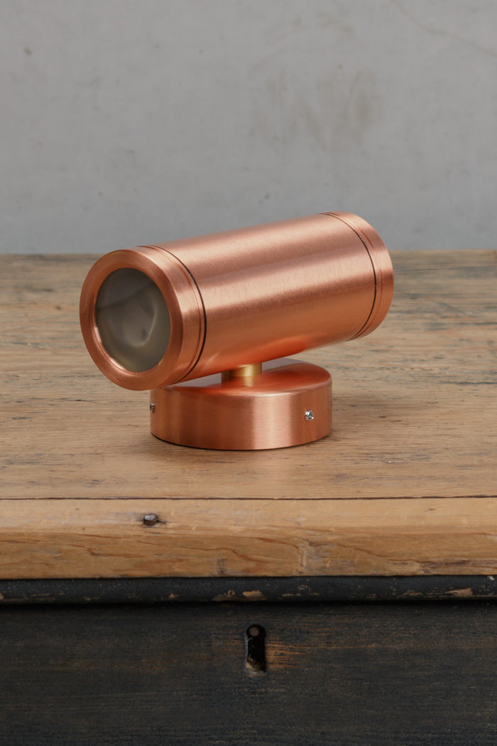 Unistalled solid copper up/down wall spot light with a polished finish.