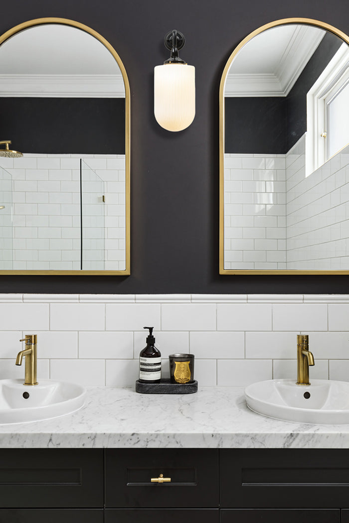 wall light in bathroom next to mirrors