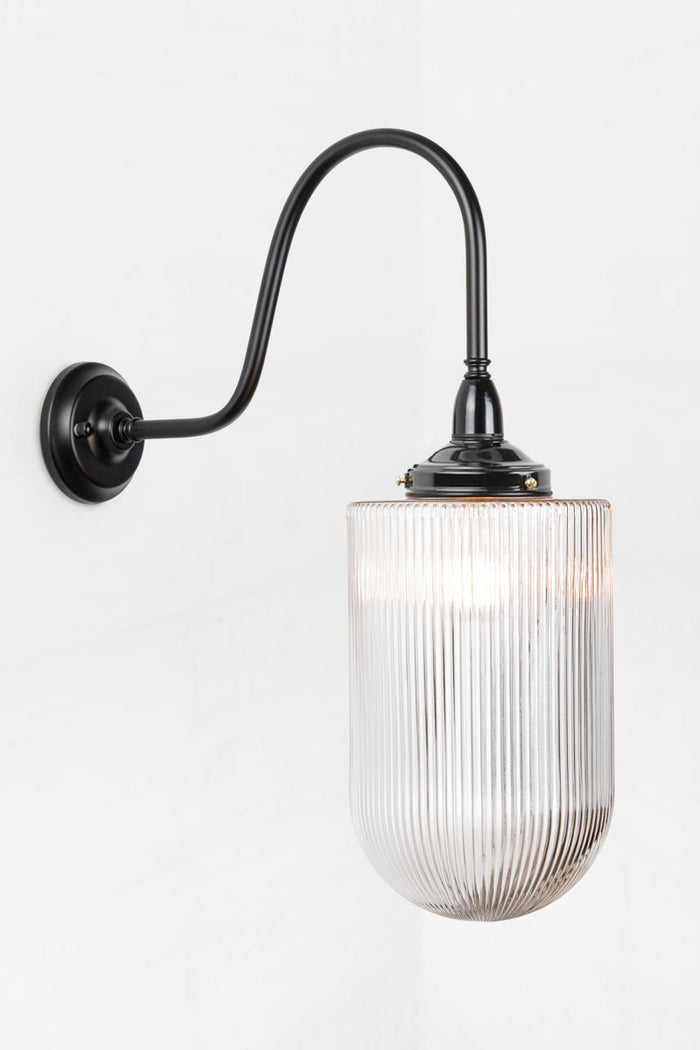Large elongated reeded clear glass shade on a black extra large gooseneck  outdoor wall light.