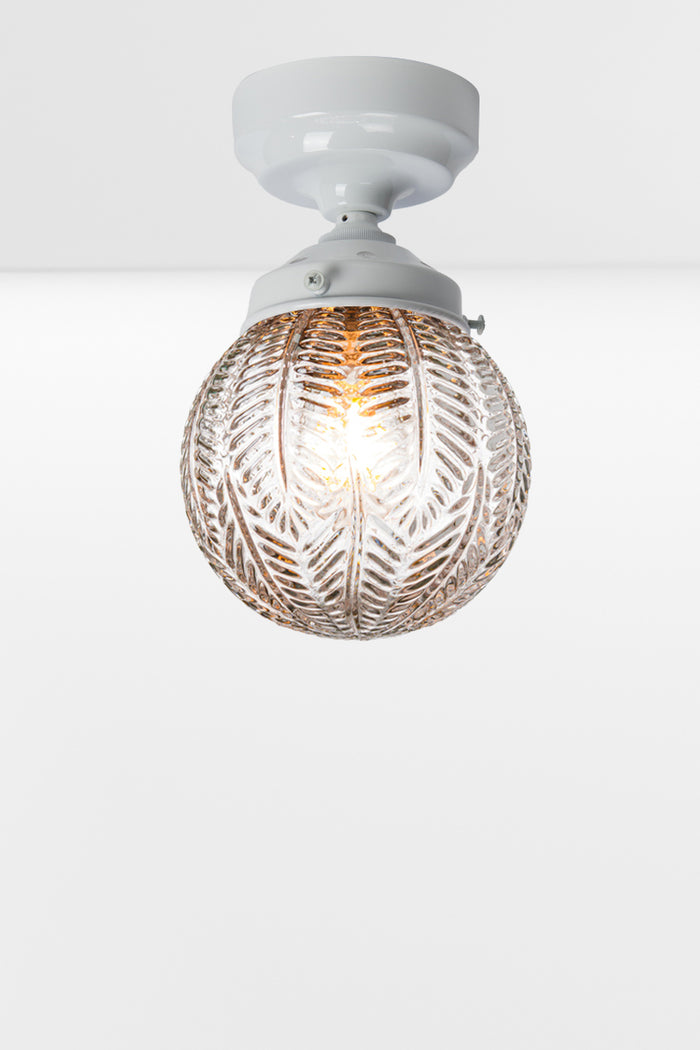 Clear glass orb shade with vintage inspired detailing on a white batten holder.