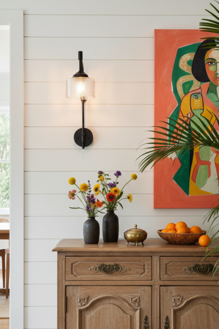 Malibu Glass Wing Arm Wall Lamp on a white shiplap wall with colourful decor.