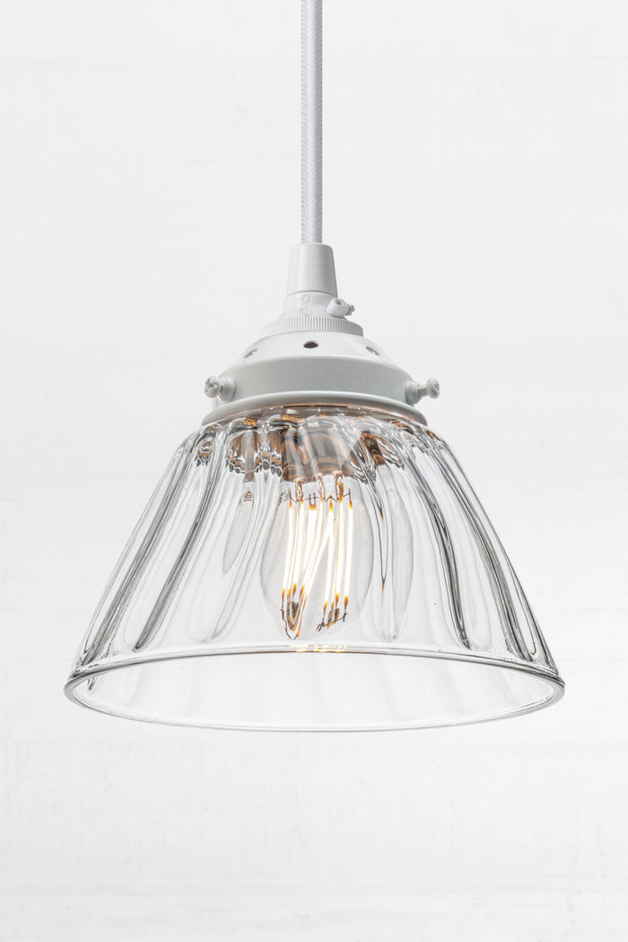 a tapered clear glass shade with a wide opening for maximum light dispersion