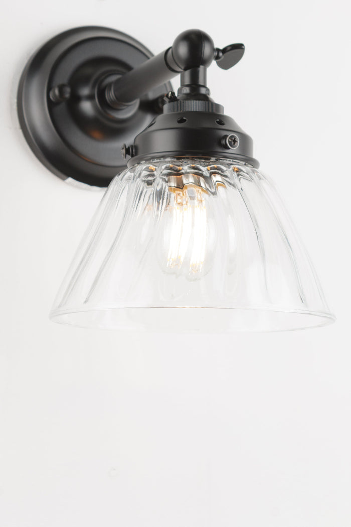 short straight wall sconce in black with a clear shade.