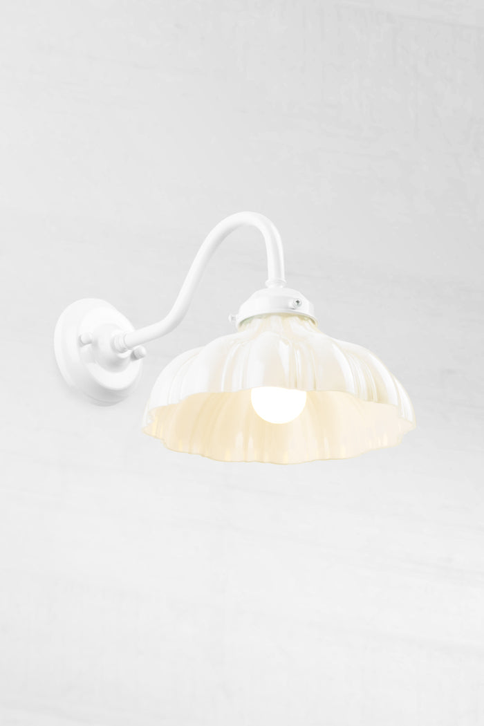 White gooseneck wall sconce with integrated gallery, paired with an opal glass shade and opaal bulb.