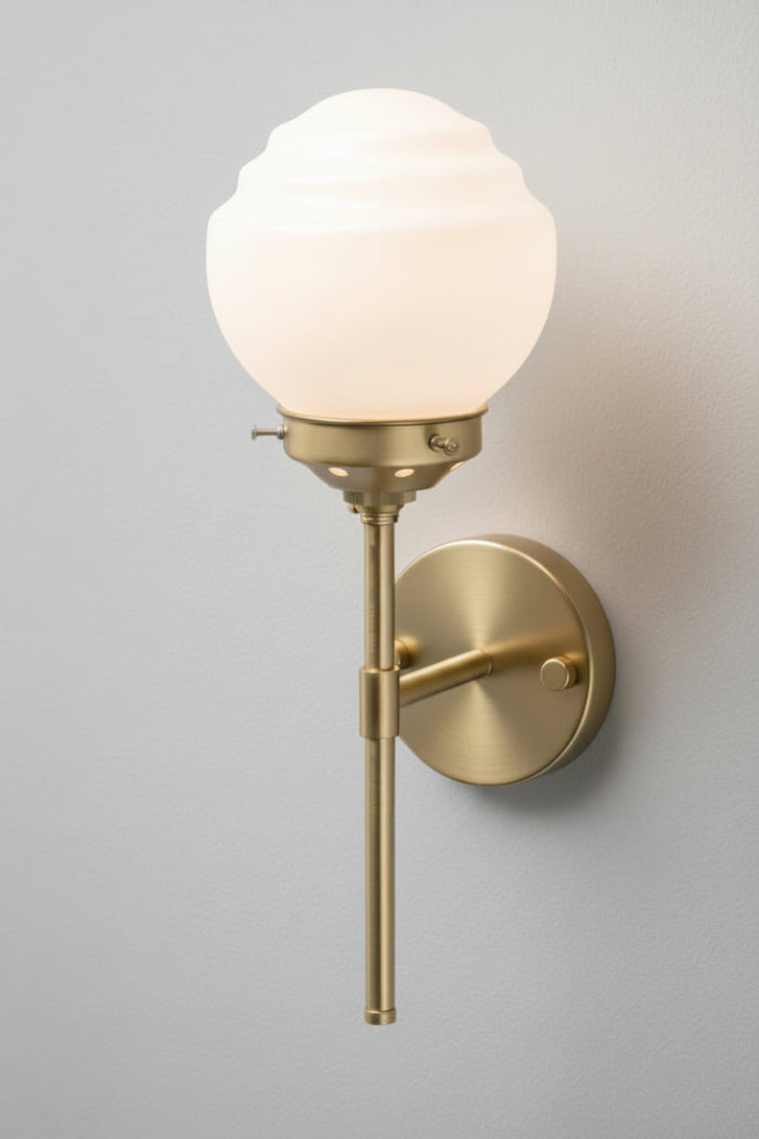 Opal shoolhouse style shade with ridged detailing on a gold/brass steel stem wall sconce