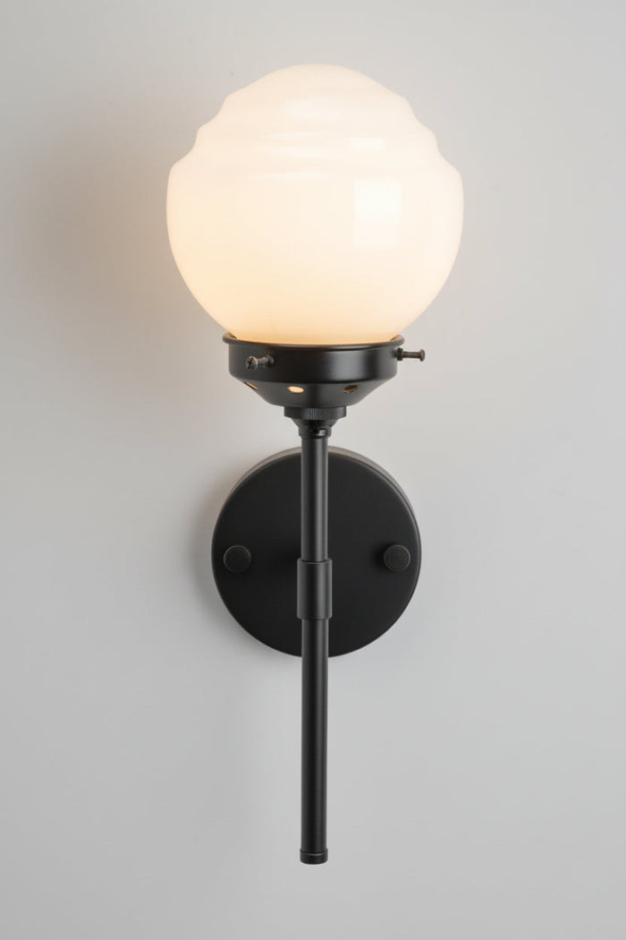 Front view of the opal glass shade on the black stem wall sonce