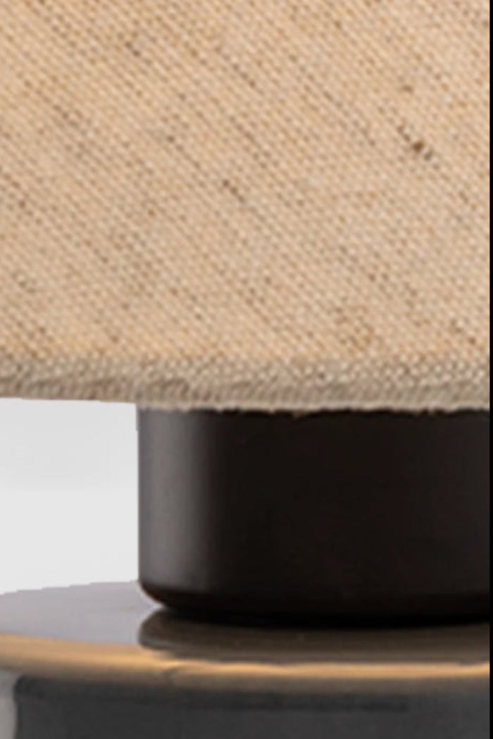 Close up Flax linen shade with a blue ceramic base.