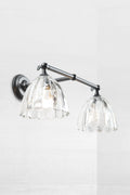 Black double swivel wall arm sconce with two clear glass shades.