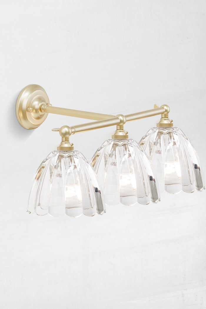 Gold brass triple straight arm, steel wall sconce with swivel lampholders for directional lighting with clear shades