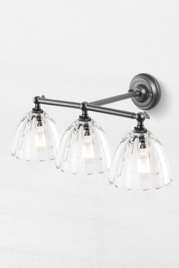 triple straight arm, steel wall sconce with swivel lampholders for directional lighting.