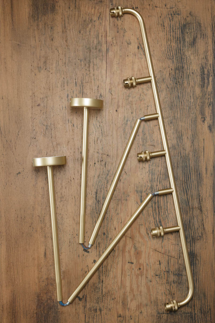 Deconstructed Five lamp linear chandelier in gold/brass.