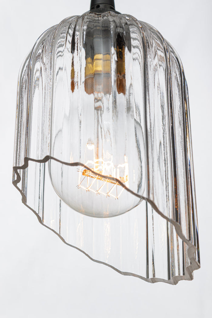 Close up of the clear glass elongated shade with fluted detailing and featuring an angle cut.