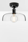 Clear glass dome shade on a black ceiling batten holder.