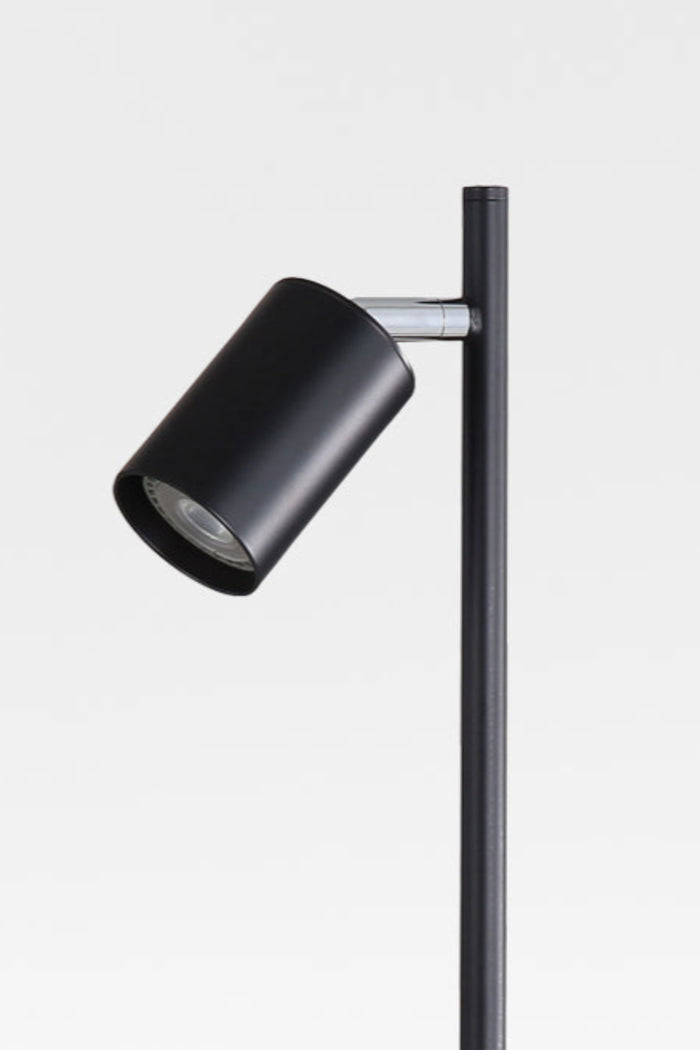Close up of the spot head of the black desk lamp with chrome accent.