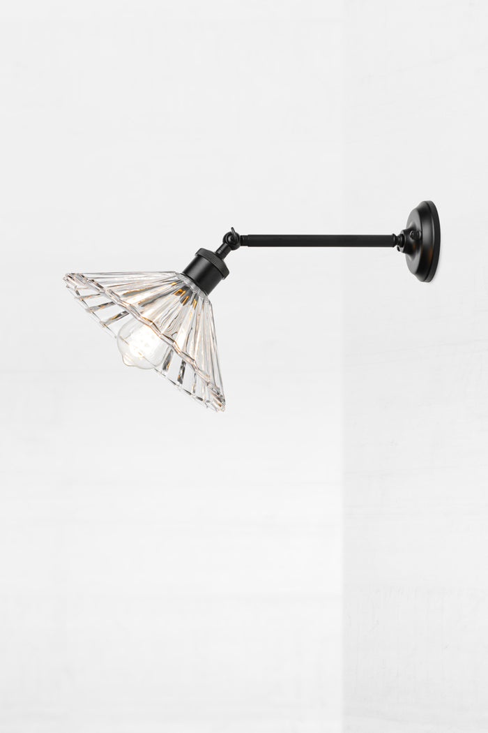Side view showing the long straight wall arm in black with glass pleated shade.