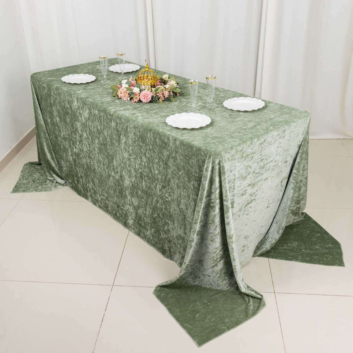 Elegant green tablecloth draped over a table with decorative floral centerpiece.