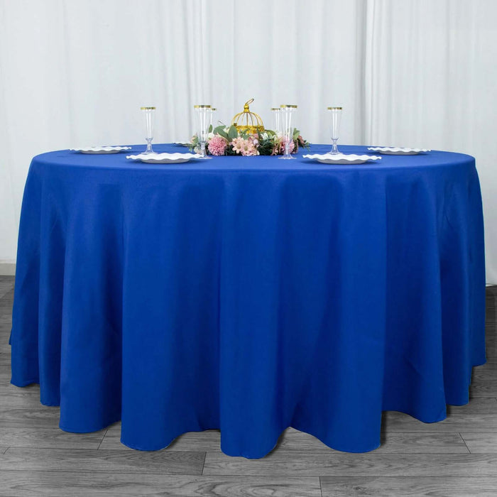 Round blue tablecloth on a round table with decorative items.