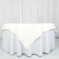 Round ivory tablecloth on a white table with draped edges.