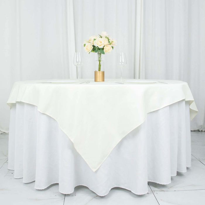 Elegant round table with a white tablecloth, adorned with a floral centerpiece.
