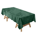 Green velvet tablecloth draped over a wooden table