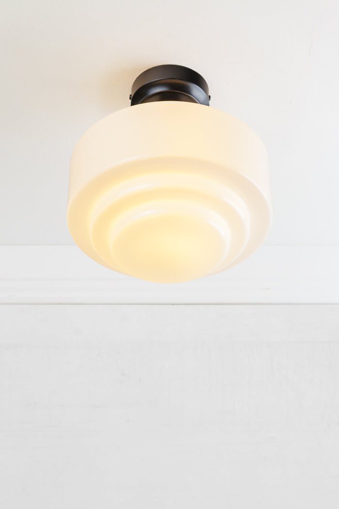 Opal glass shade with stepped silluetteand a black ceiling rose.
