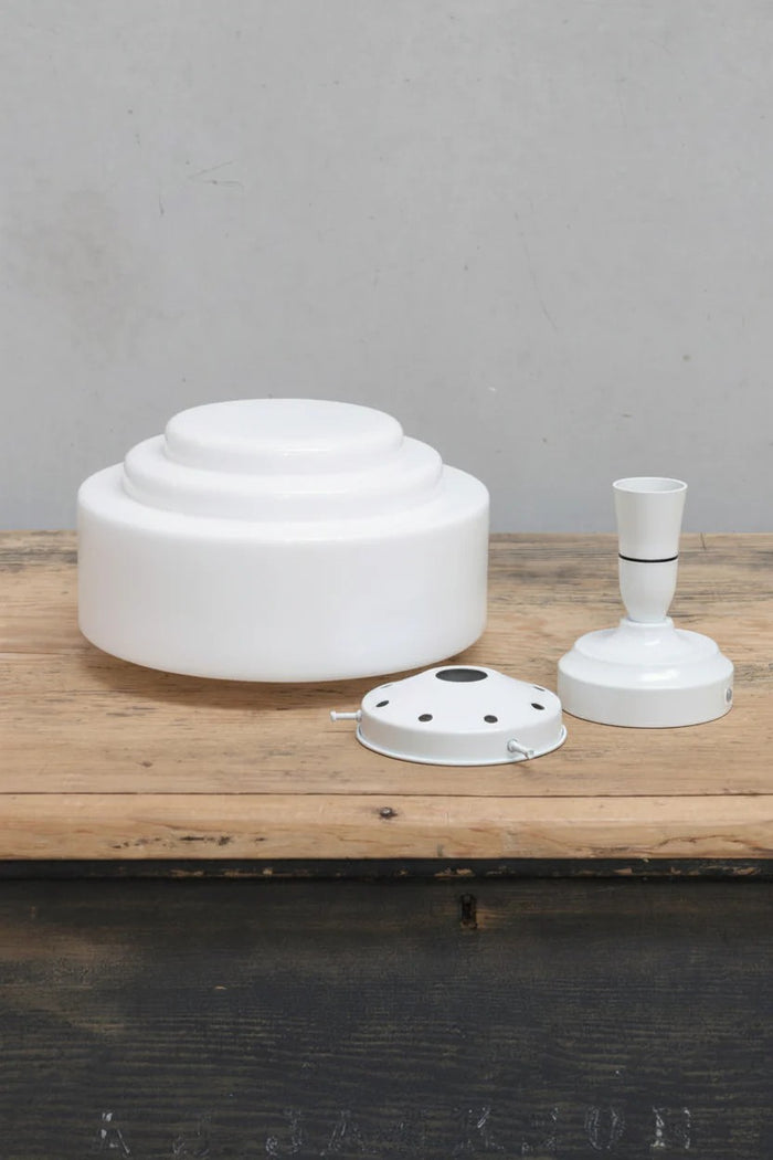 Unistalled opal glass shade with stepped silluette and a white gallery and batten holder.