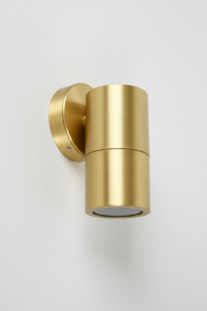 A fixed single light wall fixture with a polished brass finish.
