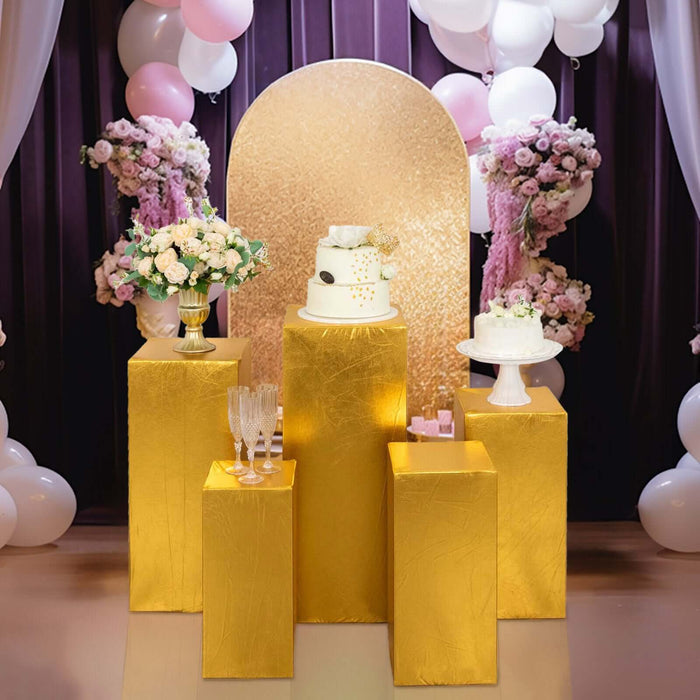 Elegant dessert display with gold pedestals, cakes, and floral arrangements.
